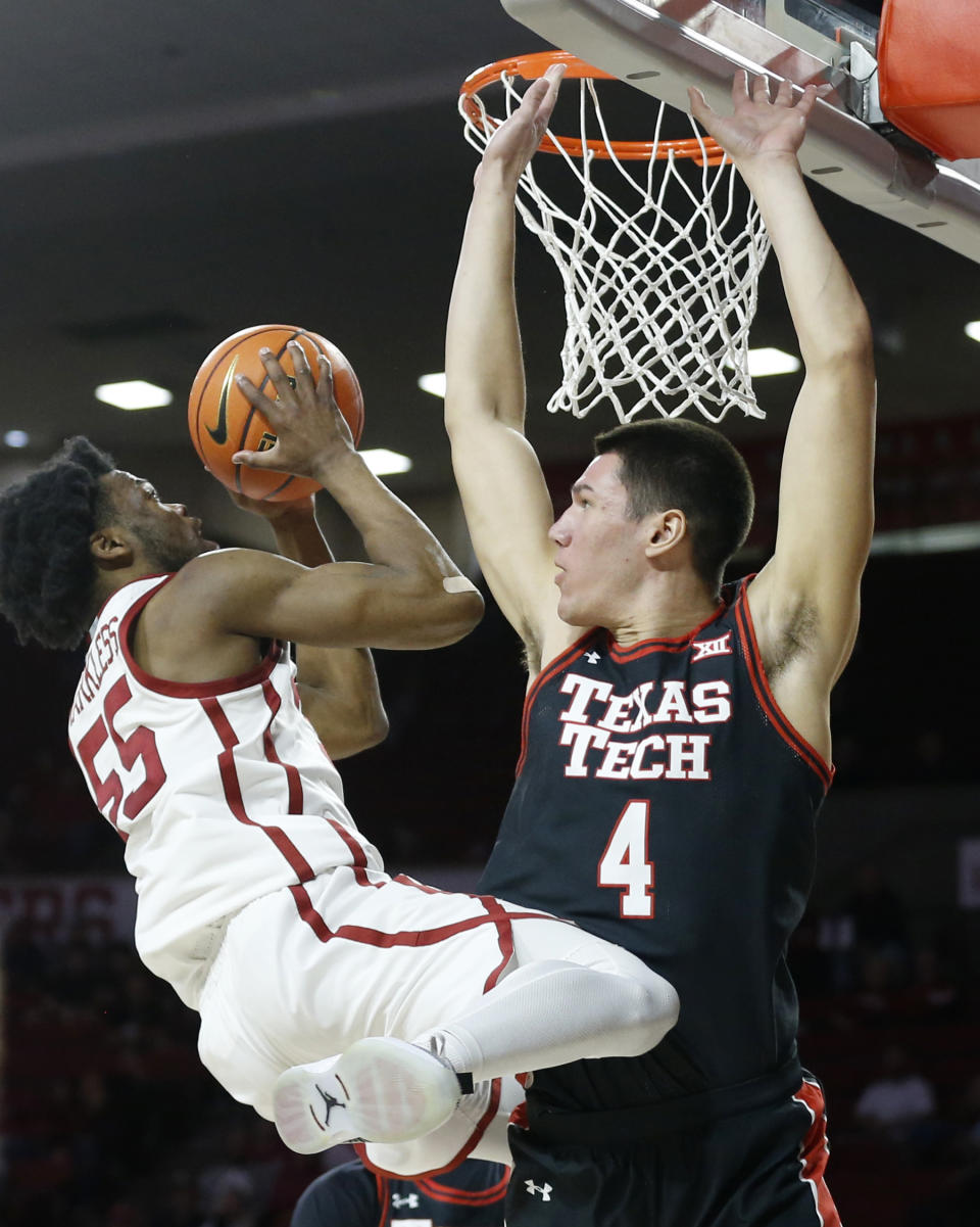 Oklahoma guard Elijah Harkless (55) shoots against Texas Tech forward Daniel Batcho (4) during the second half of an NCAA college basketball game Wednesday, Feb. 9, 2022, in Norman, Okla. (AP Photo/Garett Fisbeck)