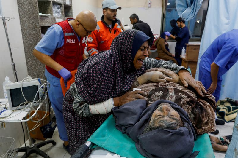 FILE PHOTO: A Palestinian woman reacts next to a wounded man at Nasser hospital following Israeli strikes in Khan Younis