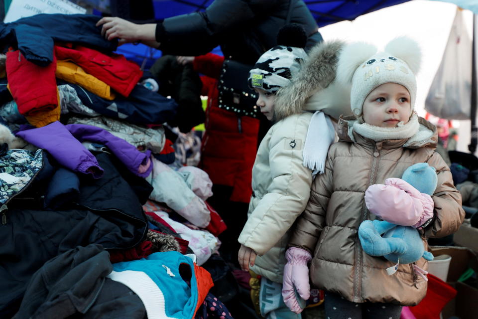 A child fleeing Russian invasion of Ukraine looks on as she stands next to a pile of clothes at a temporary camp in Przemysl, Poland, February 28, 2022. REUTERS/Yara Nardi