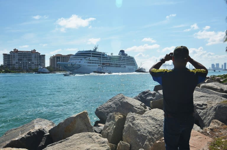 A man takes a photo of the Fathom cruise ship Adonia as she departs Miami Beach, Florida on May 1, 2016