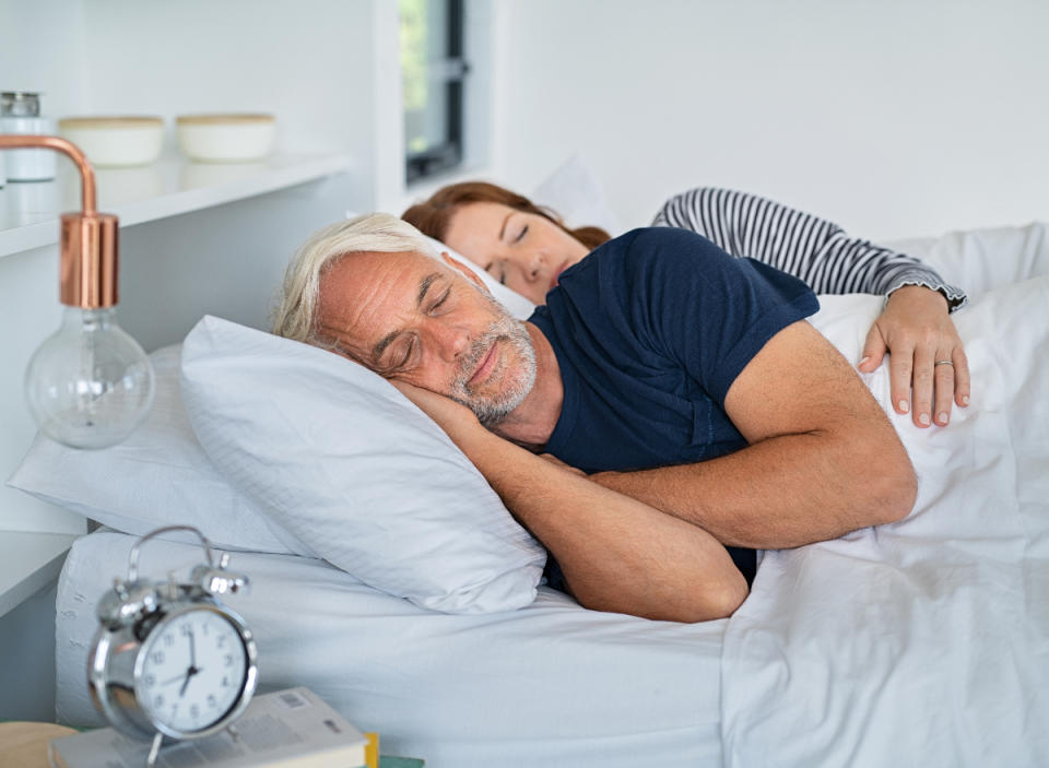 mature couple sleeping peacefully, habits that slow aging