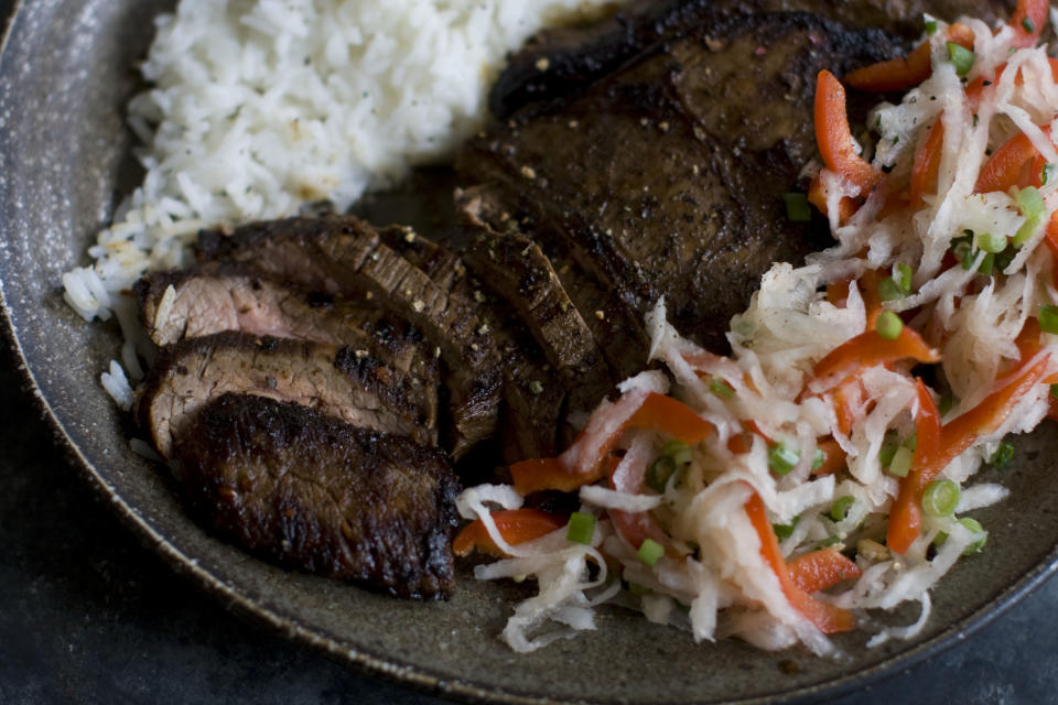 This Dec. 2, 2013 photo shows pan seared flank steak with daikon slaw in Concord, N.H. Daikon radish resemble giant white carrots, but have a mild peppery bite. (AP Photo/Matthew Mead)