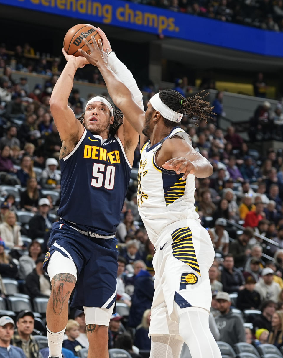 Indiana Pacers center Myles Turner, right, attempts to block a shot by Denver Nuggets forward Aaron Gordon, left, in the second half of an NBA basketball game Sunday, Jan. 14, 2024, in Denver. (AP Photo/David Zalubowski)