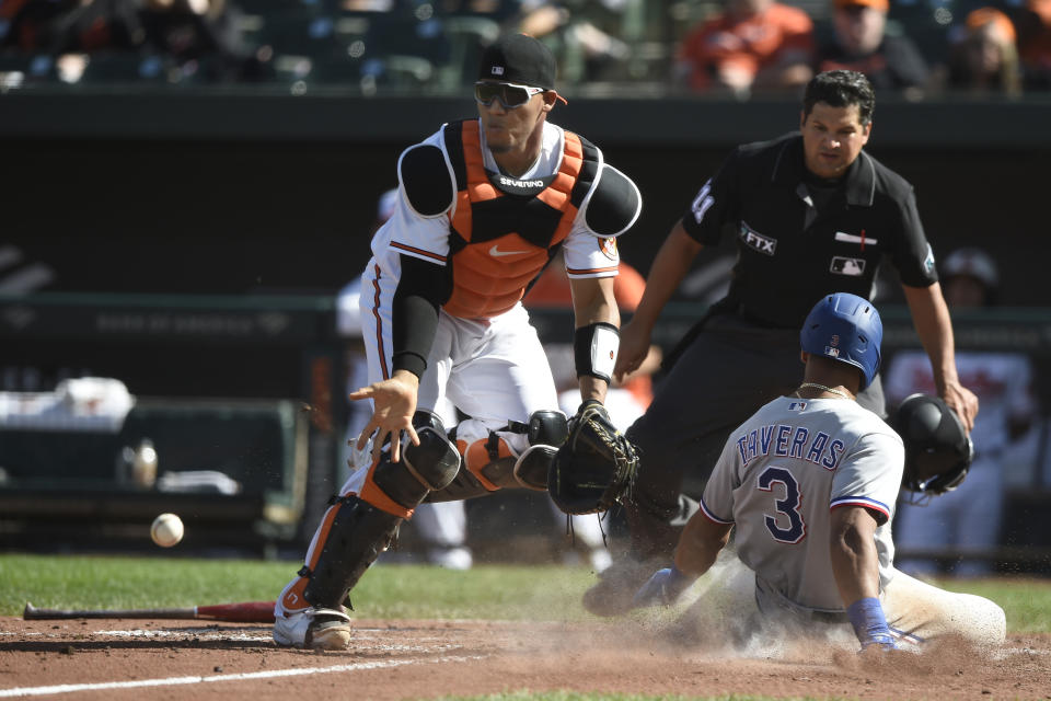 Texas Rangers' Jose Trevino is safe at the plate on a double by Isiah Kiner-Falefa, as Baltimore Orioles catcher Pedro Severino awaits the throw in the seventh inning of a baseball game. Sunday, Sept. 26, 2021, in Baltimore. (AP Photo/Gail Burton)