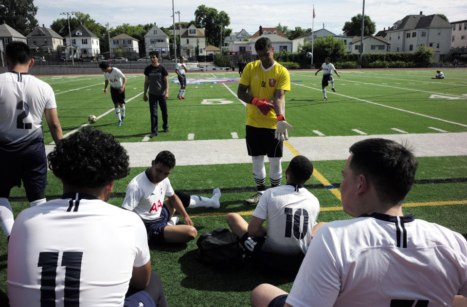 In this Sunday, June 30, 2019 photo, members of the Imperial FC amateur soccer team, one of ten teams that compete in the Latinos Soccer League, in Revere, Mass., and surrounding towns, pause during a break in their match against another amateur team named Portugal in Revere. The Latinos Soccer League hosts 10 teams with players with heritage primarily from South and Central America, and Cape Verde. (AP Photo/Steven Senne)