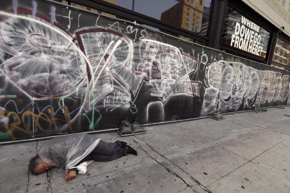 A man sleeps along Los Angeles Street in downtown L.A. on June 7, 2022.