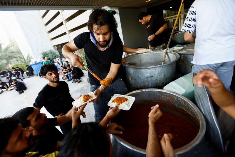 Iraqi men distribute free meals for supporters of Iraqi Shi'ite cleric Muqtada al-Sadr during a sit-in, inside the parliament building amid political crises in Baghdad