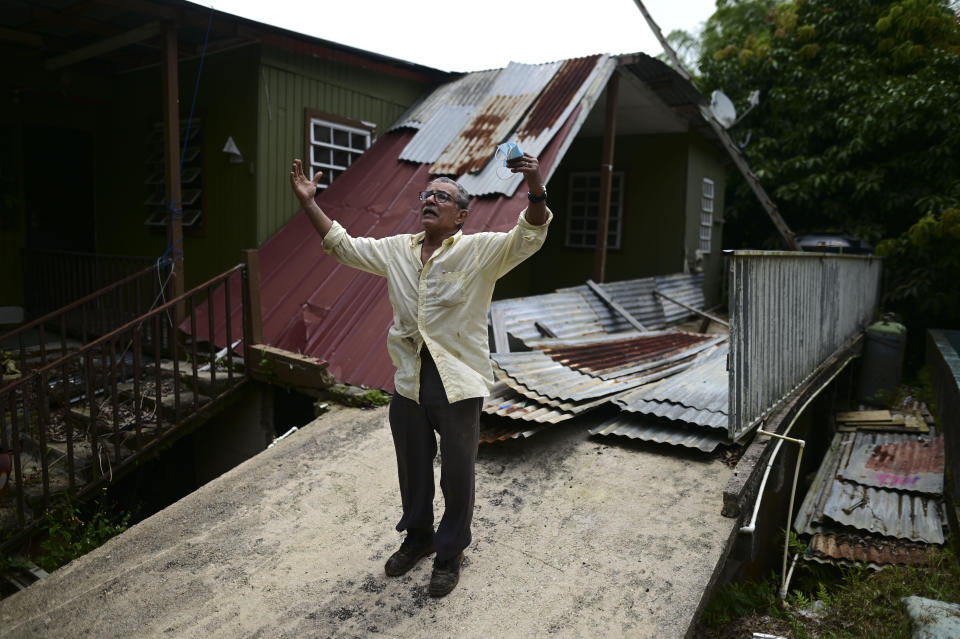 Manuel Morales Ortíz explains what his home suffered during the 2017 hurricane season, in Corozal, Puerto Rico, Monday, July 13, 2020. Nearly three years after Hurricane Maria tore through Puerto Rico, tens of thousands of homes remain badly damaged. (AP Photo/Carlos Giusti)