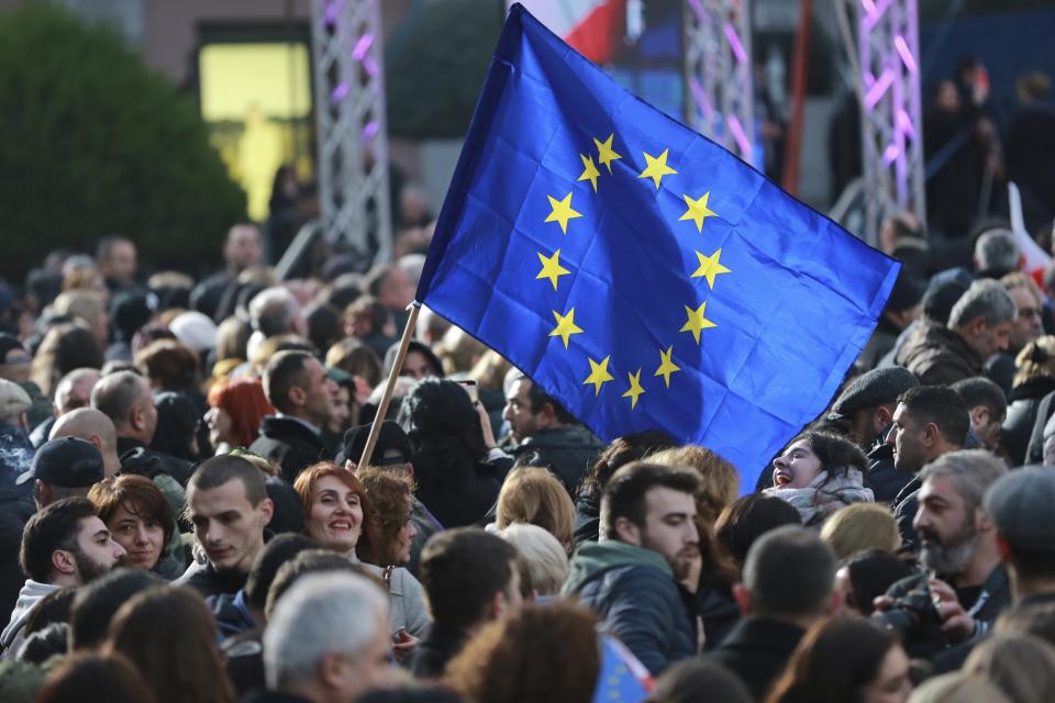 Georgians with with a EU flag gather to celebrate Georgia's EU candidacy at Liberty Square in Tbilisi, Georgia, on Friday, Dec. 15, 2023. Several thousand people attend a march in support of Georgia's EU candidacy. European Union flags waved across Georgia Friday after the European Council took a step forward along the long road towards granting Georgia and Moldova as EU membership. (AP Photo/Zurab Tsertsvadze)