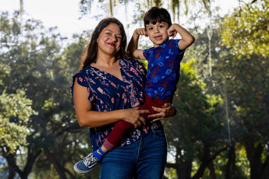 Freelance photographer and Obamacare enrollee Roxana Azuaje holds her son Kai Moreira at Legion Memorial Park in Miami, Florida, on Tuesday, December 19, 2023.