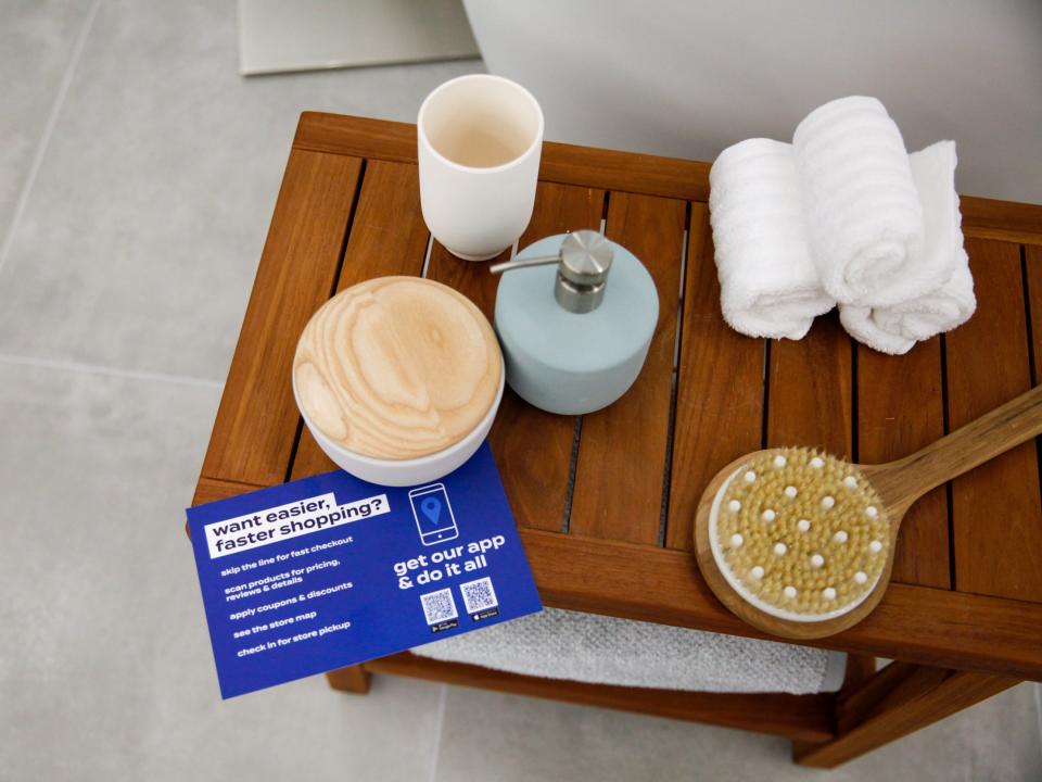 A card noting shopping through the app by bath products on display.