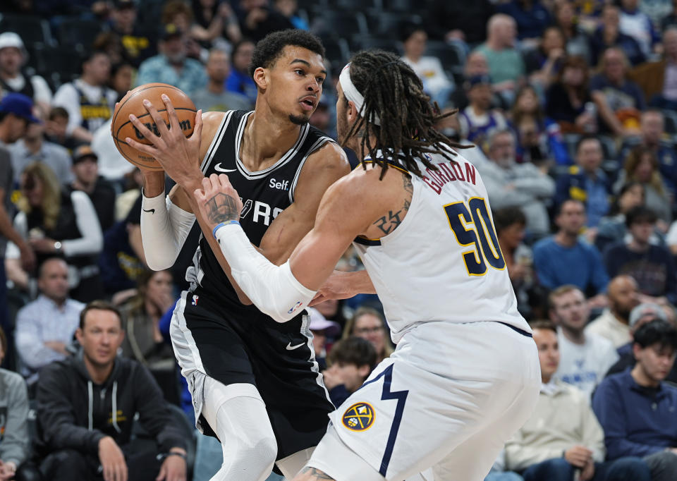 San Antonio Spurs center Victor Wembanyama, left, is defended by Denver Nuggets forward Aaron Gordon during the second half of an NBA basketball game Tuesday, April 2, 2024, in Denver. (AP Photo/David Zalubowski)