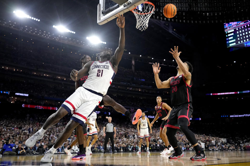 Connecticut forward Adama Sanogo (21) and San Diego State guard Matt Bradley vie for a rebound during the first half of the men's national championship college basketball game in the NCAA Tournament on Monday, April 3, 2023, in Houston. (AP Photo/Brynn Anderson)