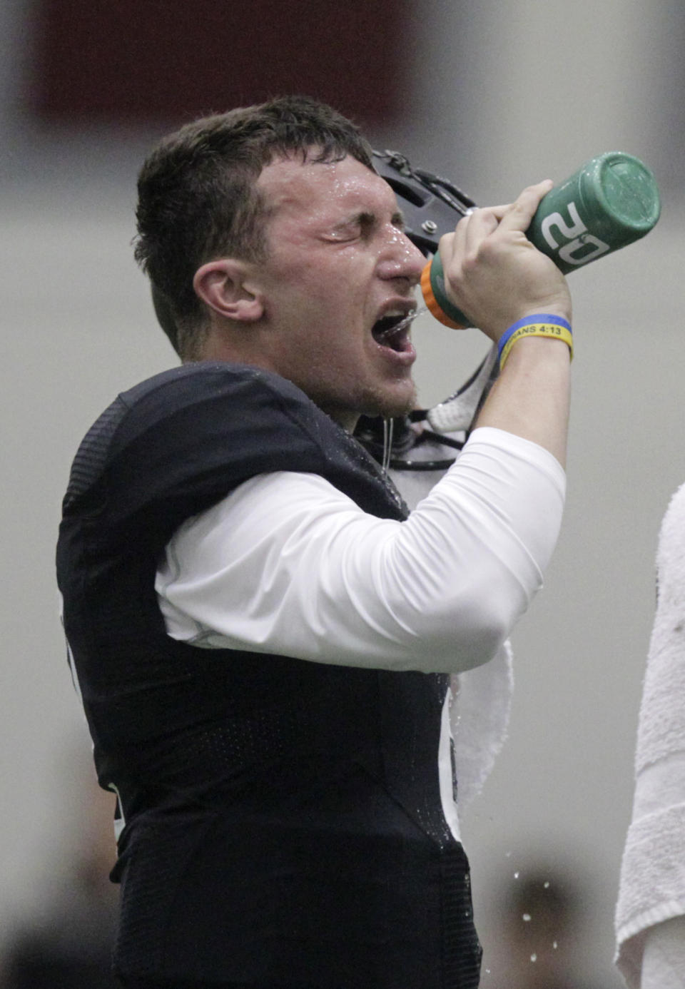 Texas A&M quarterback Johnny Manziel gets a drink at pro day for NFL football representatives in College Station, Texas, Thursday, March 27, 2014. (AP Photo/Patric Schneider)