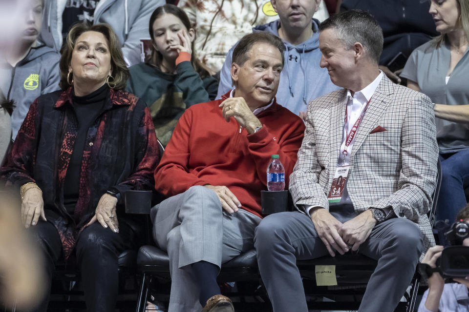 Alabama football coach Nick Saban, center, joins Alabama athletics director Greg Byrne, right, in the stands during the first half of an NCAA college basketball game between Kentucky and Alabama, Saturday, Jan. 7, 2023, in Tuscaloosa, Ala. At left is Saban's wife, Terry. (AP Photo/Vasha Hunt)