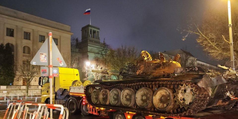 A ruined Russian T-72 tank sits on a flatbed truck at night outside the Russian embassy in Berlin, in February 2023.