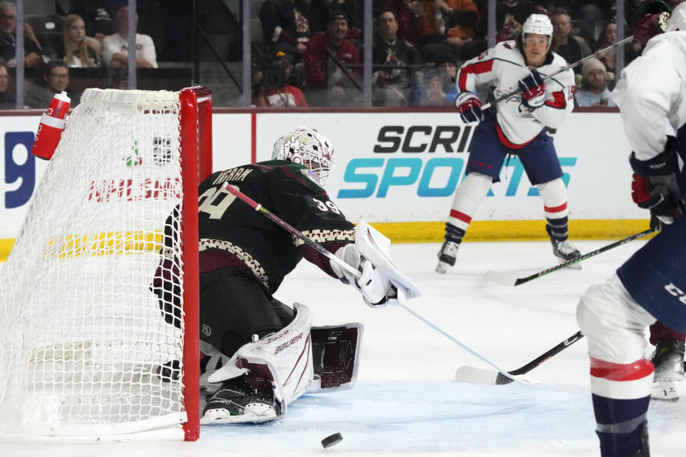 Arizona Coyotes goaltender Connor Ingram (39) makes a save on a shot by Washington Capitals left wing Sonny Milano, right, during the second period of an NHL hockey game Monday, Dec. 4, 2023, in Tempe, Ariz. (AP Photo/Ross D. Franklin)