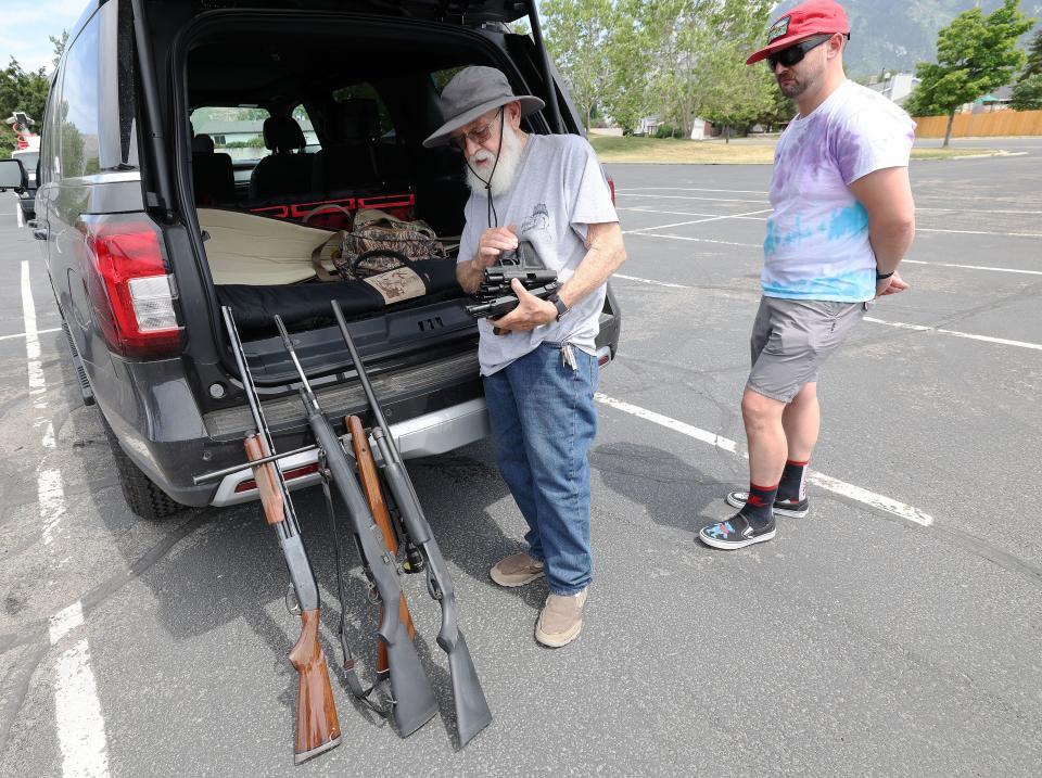 Patrick Hvolka, right, turns in several guns to Mike Vallez during a Guns to Gardens event at Community of Grace Presbyterian Church in Sandy on Saturday, June 11, 2022. The Gun Violence Prevention Center of Utah, in partnership with the Presbyterian Peace Fellowship, wanted to safely dismantle unwanted unloaded firearms and turn them into garden tools. | Jeffrey D. Allred, Deseret News