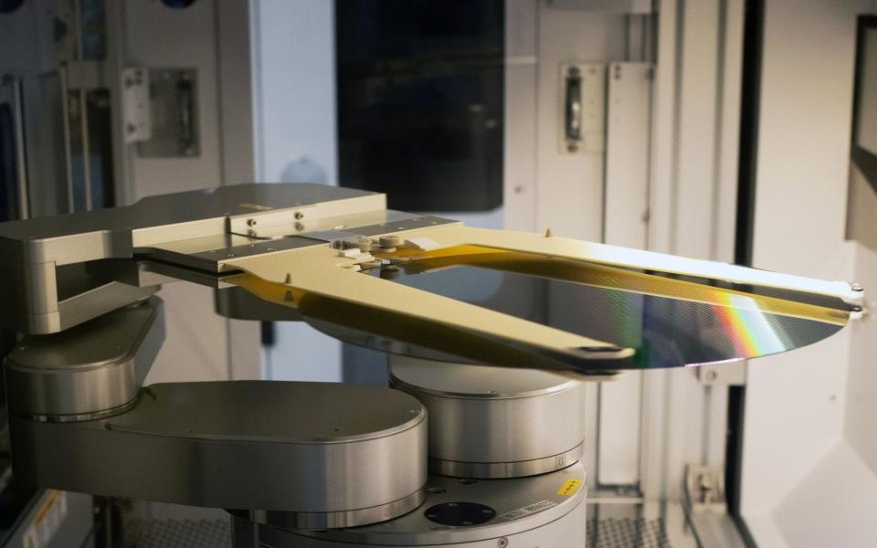 A robotic arm moves a 300 mm silicon semiconductor wafer inside a sorting machine in a cleanroom at the Globalfoundries Inc. semiconductor fabrication plant in Dresden, Germany, on Wednesday, Nov. 30, 2022. As the US has implemented unexpectedly strict rules on the transfer of semiconductor technology to China, the EU has paved the way for chipmakers to receive unprecedented state funds to build production sites as part of its EU Chips Act. Photographer: Liesa Johannssen/Bloomberg - Liesa Johannssen/Bloomberg