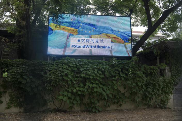 A video board displays a message of support for Ukraine outside the Delegation of the European Union in Beijing, Wednesday, May 17, 2023. Embassies in Beijing have been asked by the Chinese government to avoid displaying propaganda after some raised Ukrainian flags or set up placards declaring support for Ukraine. (AP Photo/Mark Schiefelbein)