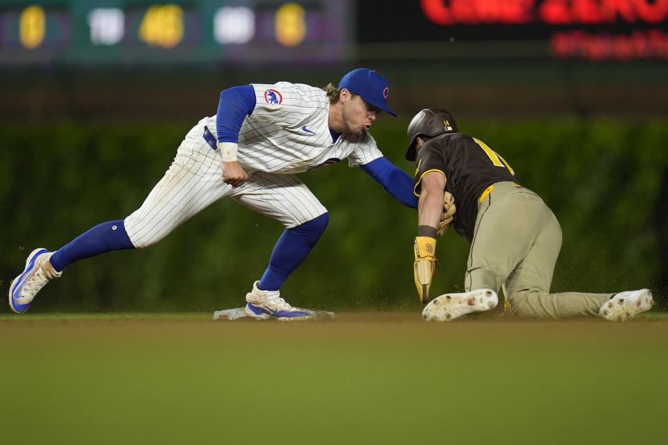 Chicago Cubs second baseman Nico Hoerner, left, catches San Diego Padres' Tyler Wade, right, who was trying to steal second during the eighth inning of a baseball game Monday, May 6, 2024, in Chicago. (AP Photo/Erin Hooley)
