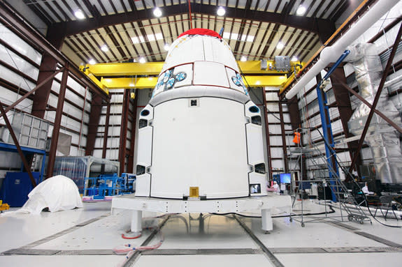 The Space Exploration Technologies, or SpaceX, Dragon spacecraft with solar array fairings attached, stands inside a processing hangar at Cape Canaveral Air Force Station, Fla. The spacecraft will launch on the upcoming SpaceX CRS-2 mission. I