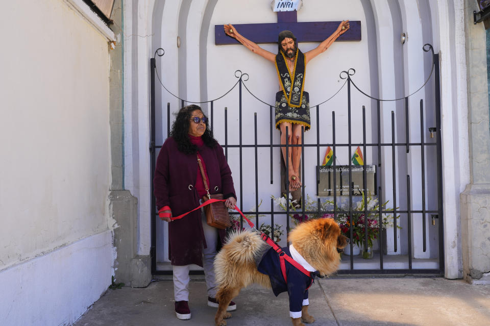 Una mujer y su perro asisten a una misa en la iglesia del Cuerpo de Cristo por las celebraciones del día de San Roque, considerado el santo patrón de los perros, en El Alto, Bolivia, el miércoles 16 de agosto de 2023. (AP Foto/Juan Karita)