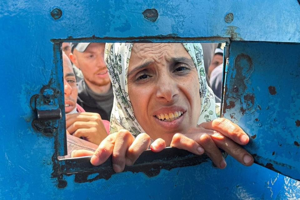 A Palestinian woman waits to receive aid from a UNRWA distribution in Rafah (Reuters)