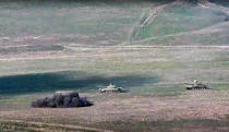 In this image taken from a footage released by Armenian Defense Ministry on Sunday, Sept. 27, 2020, Armenian army destroys Azerbaijani tanks at the contact line of the self-proclaimed Republic of Nagorno-Karabakh, Azerbaijan. Fighting between Armenia and Azerbaijan has broken out around the separatist region of Nagorno-Karabakh and the Armenian Defense Ministry says two Azerbaijani helicopters have been shot down. Ministry spokeswoman Shushan Stepanyan also said Armenian forces hit three Azerbaijani tanks. (Armenian Defense Ministry via AP)