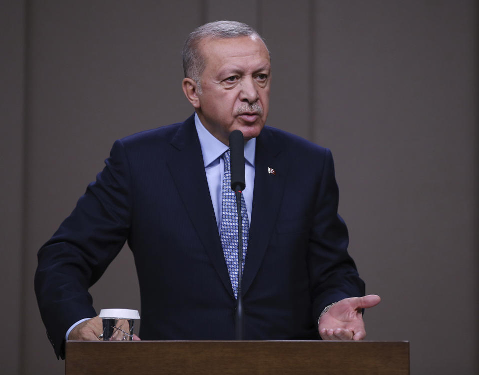 Turkish President Recep Tayyip Erdogan talks to reporters before traveling to Russia to meet with Russian President Vladimir Putin, in Ankara, Tuesday, Oct. 22, 2019. Erdogan says up to 1,300 Syrian Kurdish militia have yet to vacate areas in northeast Syria, as the clock a Turkish-U.S. cease-fire agreement runs. (Presidential Press Service via AP, Pool )