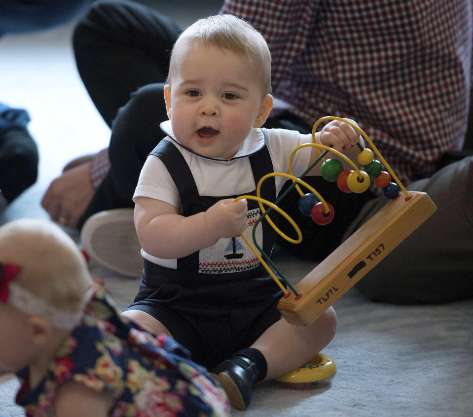 Britain's Prince George plays during a visit to Plunket nurse and parents group at Government House in Wellington, New Zealand, Wednesday, April 9, 2014. Plunket is a national not-for-profit organization that provides care for children and families in New Zealand. Britain's Prince William, his wife Kate, the Duchess of Cambridge and their son, Prince George, are on a three-week tour of New Zealand and Australia. (AP Photo/Marty Melville, Pool)