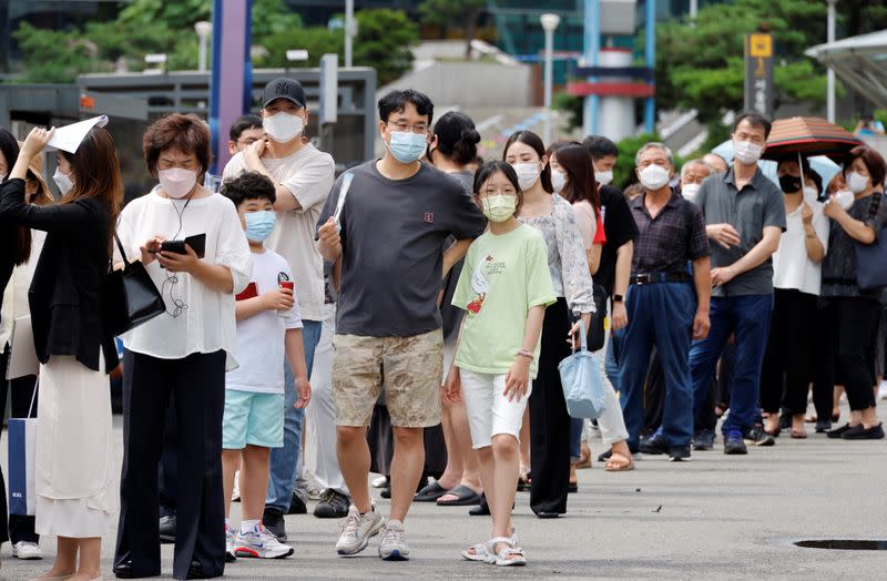 People wait in line for a coronavirus disease (COVID-19) test at a testing site which is temporarily set up at a railway station in Seoul