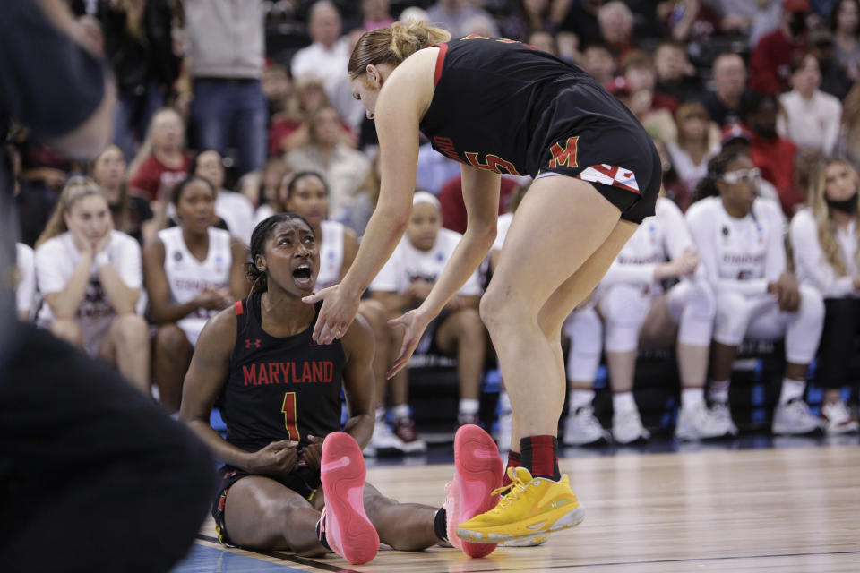 Maryland guard Diamond Miller (1) reacts as she is helped up by forward Chloe Bibby, right, during the second half of a college basketball game against Stanford in the Sweet 16 round of the NCAA tournament, Friday, March 25, 2022, in Spokane, Wash. (AP Photo/Young Kwak)