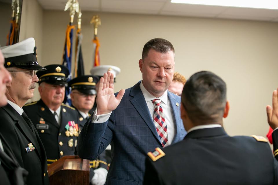 Psychologist Jeffrey Bates is sworn in as a captain in the U.S. Army Reserve by Army Capt. Jose Linares at the Veterans Service Center in Ocala on Feb. 15.