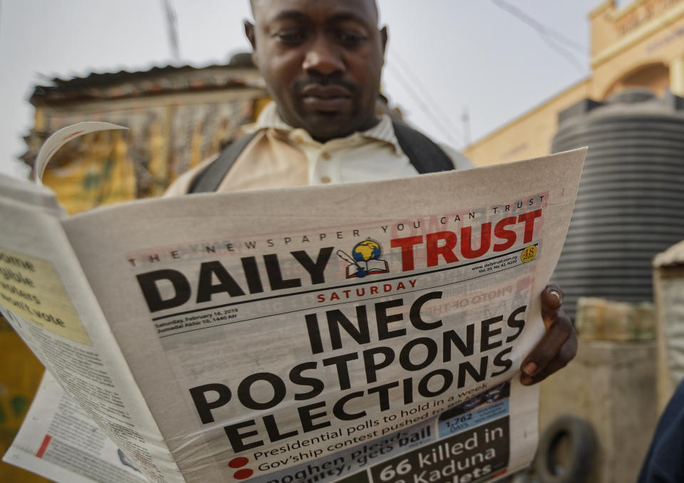 A man reads a copy of a newspaper which managed to print the news of the postponement in time, in the morning at a newspaper stand in Kano, northern Nigeria Saturday, Feb. 16, 2019. Nigeria's electoral commission delayed the presidential election until Feb. 23, making the announcement a mere five hours before polls were set to open Saturday. (AP Photo/Ben Curtis)