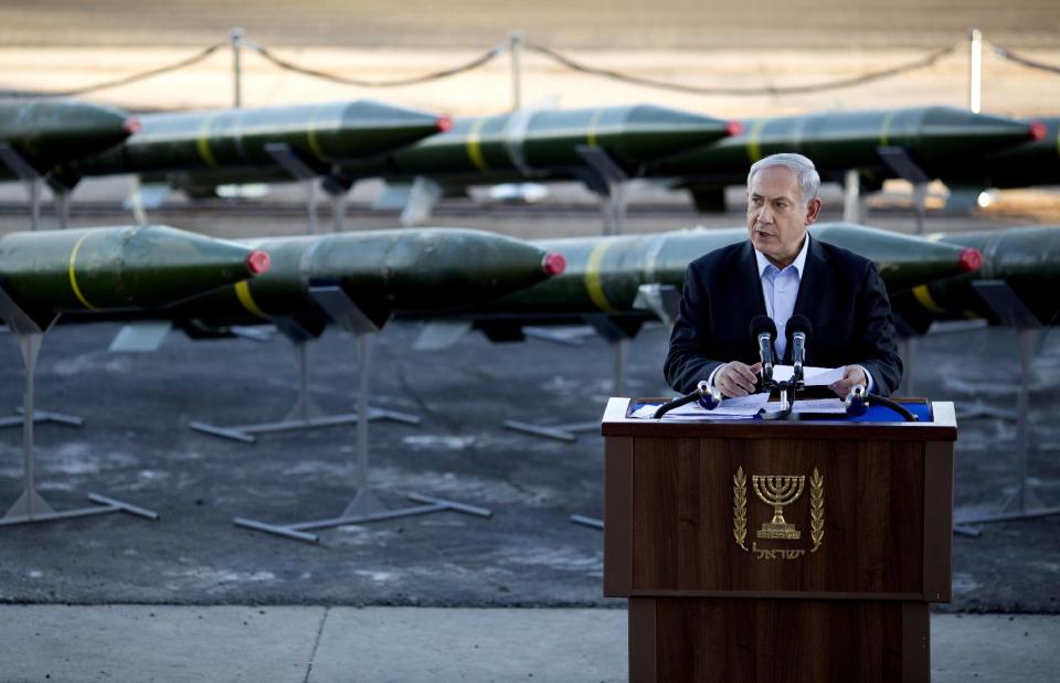 Israel's Prime Minister Benjamin Netanyahu speaks as dozens rockets on display after being seized from the Panama-flagged KLOS C civilian cargo ship that Israel intercepted last Wednesday off the coast of Sudan, at a military port in the Red Sea city of Eilat, southern Israel, Monday, March 10, 2014. Israel has alleged the shipment was orchestrated by Iran and was intended for Islamic militants in Gaza, a claim denied by Iran and the rockets' purported recipients. Questions remain, including how the rockets would have been smuggled into Gaza, largely cut off from the world by a border blockade enforced by Israel and Egypt. (AP Photo/Ariel Schalit)