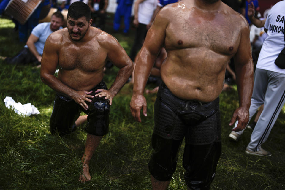 Wrestlers warm up while waiting for their turn to wrestle during the 663rd annual Historic Kirkpinar Oil Wrestling championship, in Edirne, northwestern Turkey, Saturday, July 6, 2024. Wrestlers take part in this "sudden death"-style traditional competition wearing only a pair of leather trousers and a good slick of olive oil. The festival is part of UNESCO's List of Intangible Cultural Heritages. (AP Photo/Khalil Hamra)