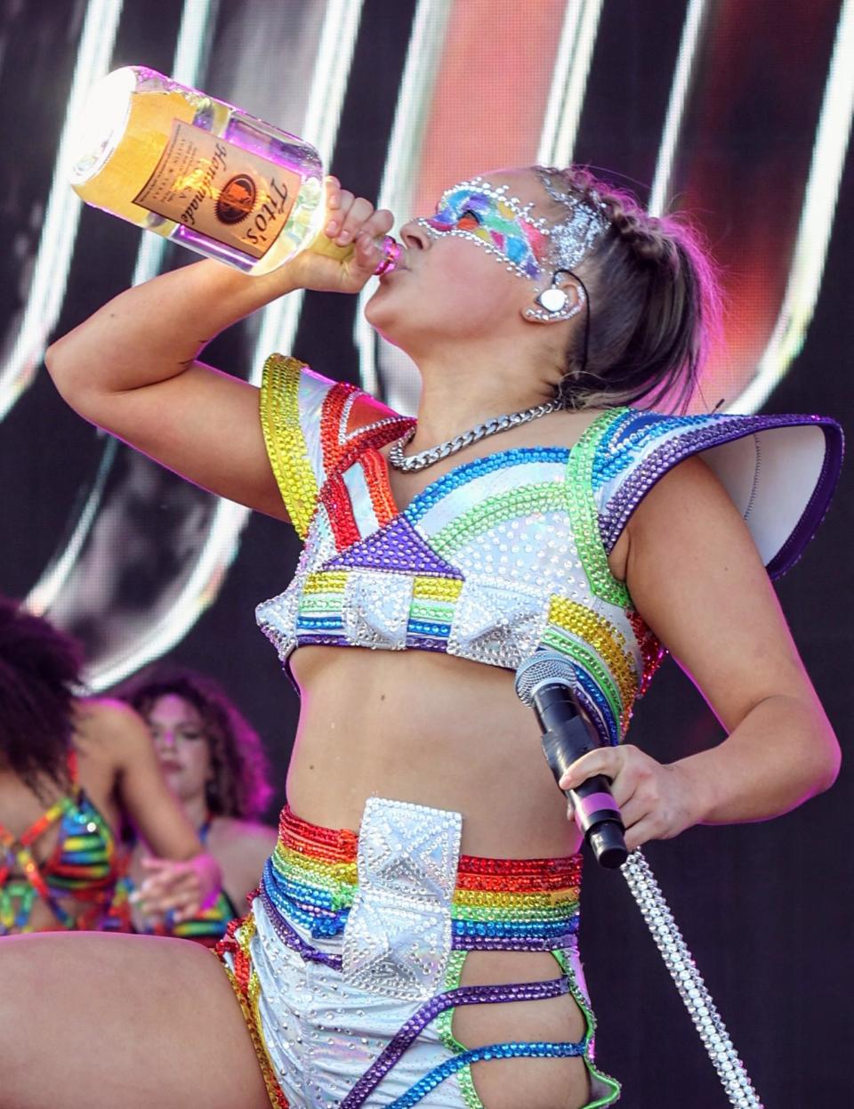 Jojo Siwa drinks from a Tito's vodka bottle on stage