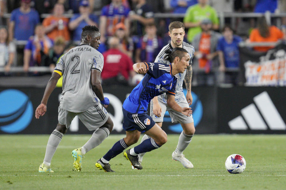 FC Cincinnati forward Yuya Kubo, center, dribbles against CF Montréal's Victor Wanyama (2) and Gabriele Corbo during the second half of an MLS soccer match Wednesday, May 17, 2023, in Cincinnati. (AP Photo/Jeff Dean)