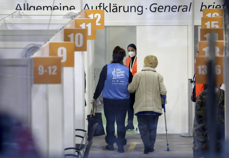 A person is guided in a new coronavirus, COVID-19, vaccination center at the 'Erika-Hess-Ice-Stadium' in Berlin, Germany, Thursday, Jan. 14, 2021. The first doses of the Moderna vaccine are distributed at that vaccination center in Berlin. (AP Photo/Michael Sohn)