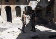 Ahmad Abu Layl (L), a 15 year-old fighter from the Free Syrian Army, chats with his father in Aleppo September 10, 2013. REUTERS/Hamid Khatib