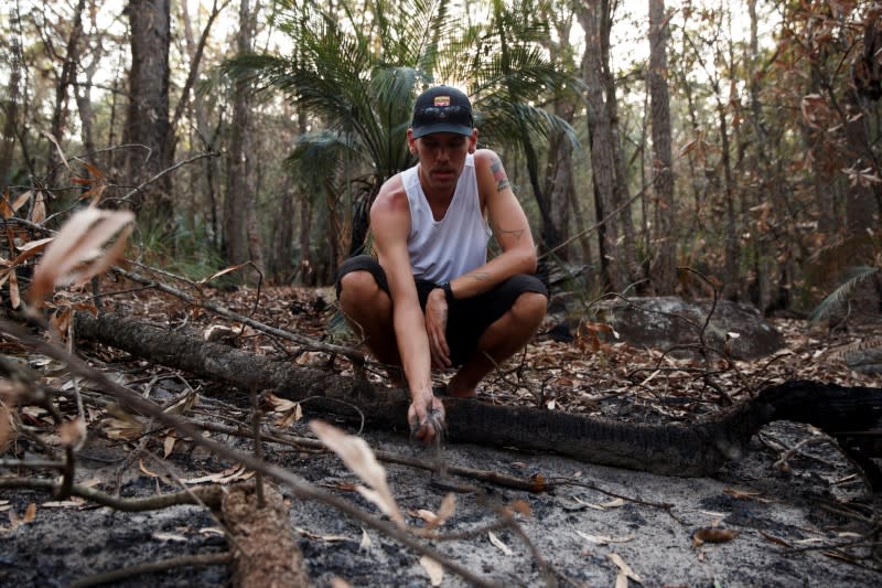 Indigenous Australian Jacob Morris, who was taught ancient burning techniques by his family, tests the quality of the forest soil as he speaks about cultural burning in Illaroo