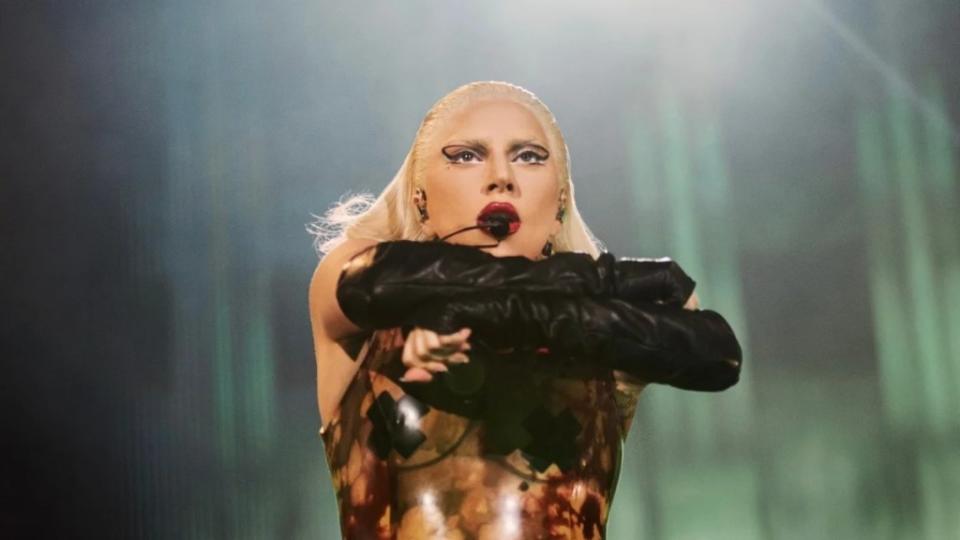 A woman with blond hair dances and sings on stage