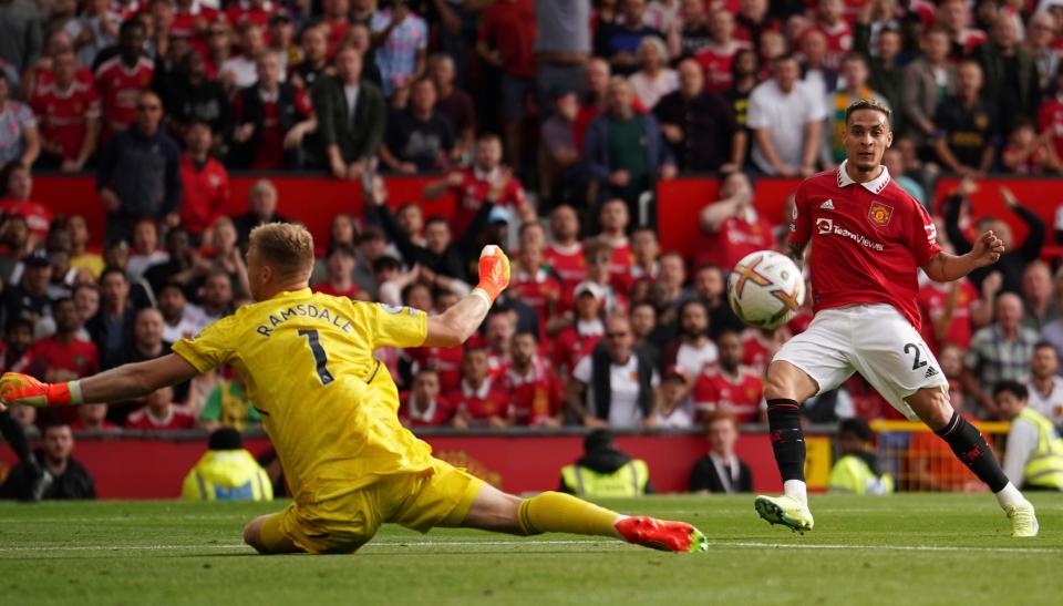 Manchester United's Antony, right, scores his side's opening goal past Arsenal's goalkeeper Aaron Ramsdale during the English Premier League soccer match between Manchester United and Arsenal at Old Trafford stadium, in Manchester, England, Sunday, Sept. 4, 2022. (AP Photo/Dave Thompson)