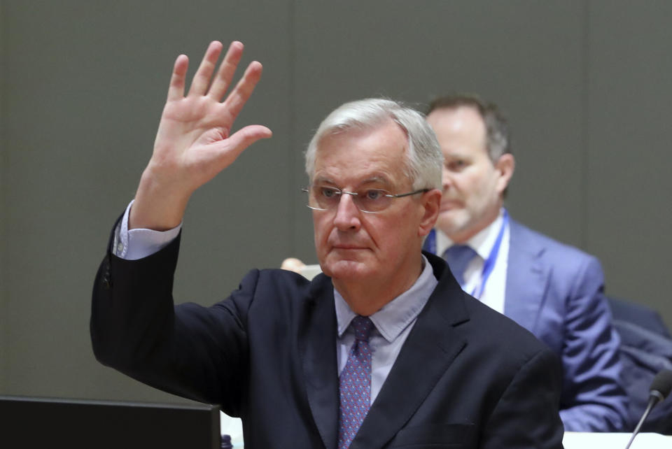 European Commission's Head of Task Force for Relations with the United Kingdom Michel Barnier raises his hand during a meeting of ambassadors of European Union governments in Brussels, Monday, Dec. 14, 2020. Teetering on the brink of a no-deal Brexit departure, Britain and the European Union stepped back from the void Sunday and agreed to continue trade talks, although both downplayed the chances of success. (Yves Herman, Pool Photo via AP)