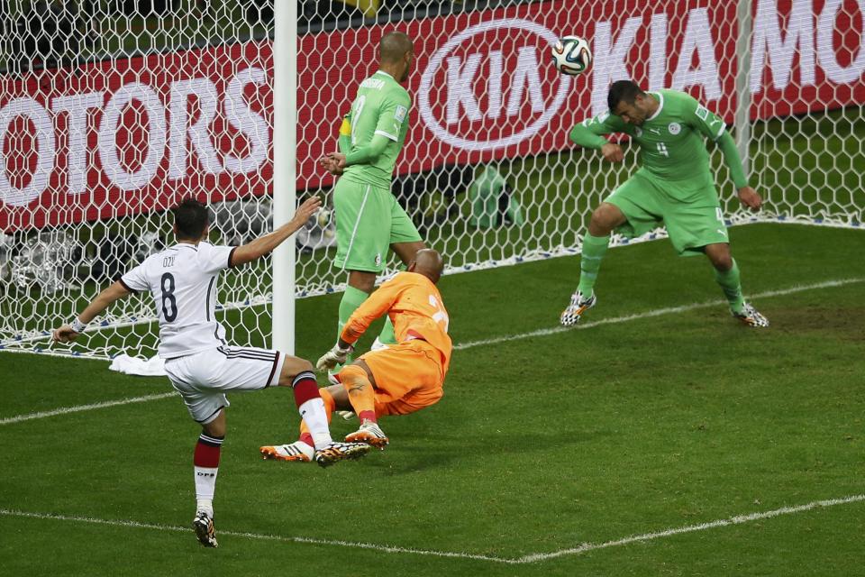 Germany's Mesut Ozil (L) scores against Algeria during their 2014 World Cup round of 16 game at the Beira Rio stadium in Porto Alegre June 30, 2014. REUTERS/Leonhard Foeger