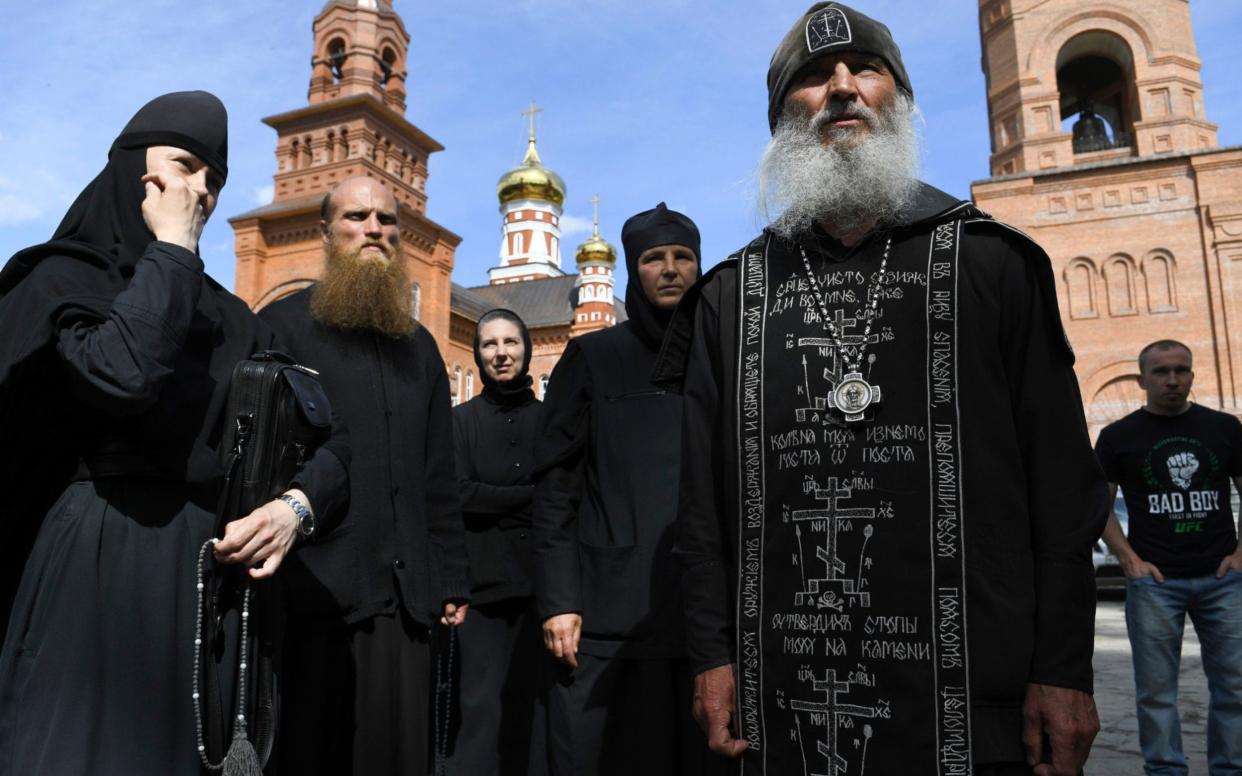 Father Sergei, right, has long been accused of running a religious cult - Vladimir Podoksyonov/AP