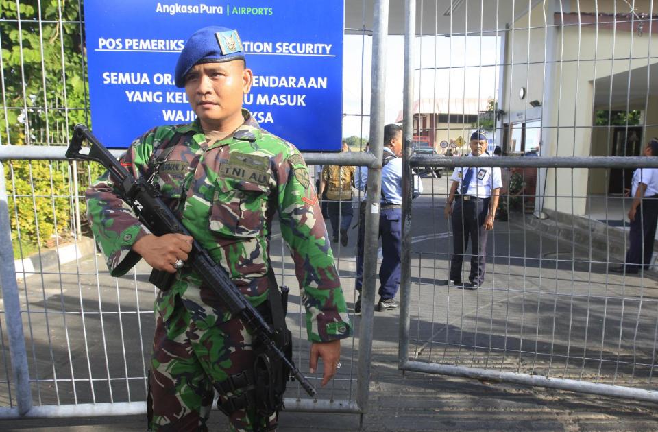An Indonesian military soldier stands guard at Bali's international airport, Indonesia, Friday, April 25, 2015. A drunken passenger who caused a hijack scare on a Virgin Australia flight by trying to break into the cockpit was arrested Friday after the plane landed on Indonesia's resort island of Bali, officials said. (AP Photo/Firdia Lisnawati)