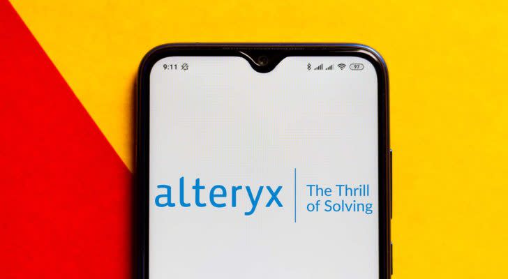 The Alteryx (AYX) logo is displayed on a smartphone screen.