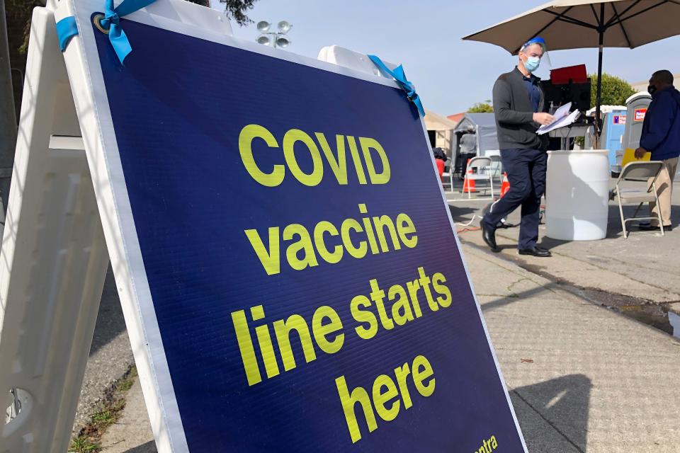 A sign reading "COVID vaccine line starts here" in San Franisco.